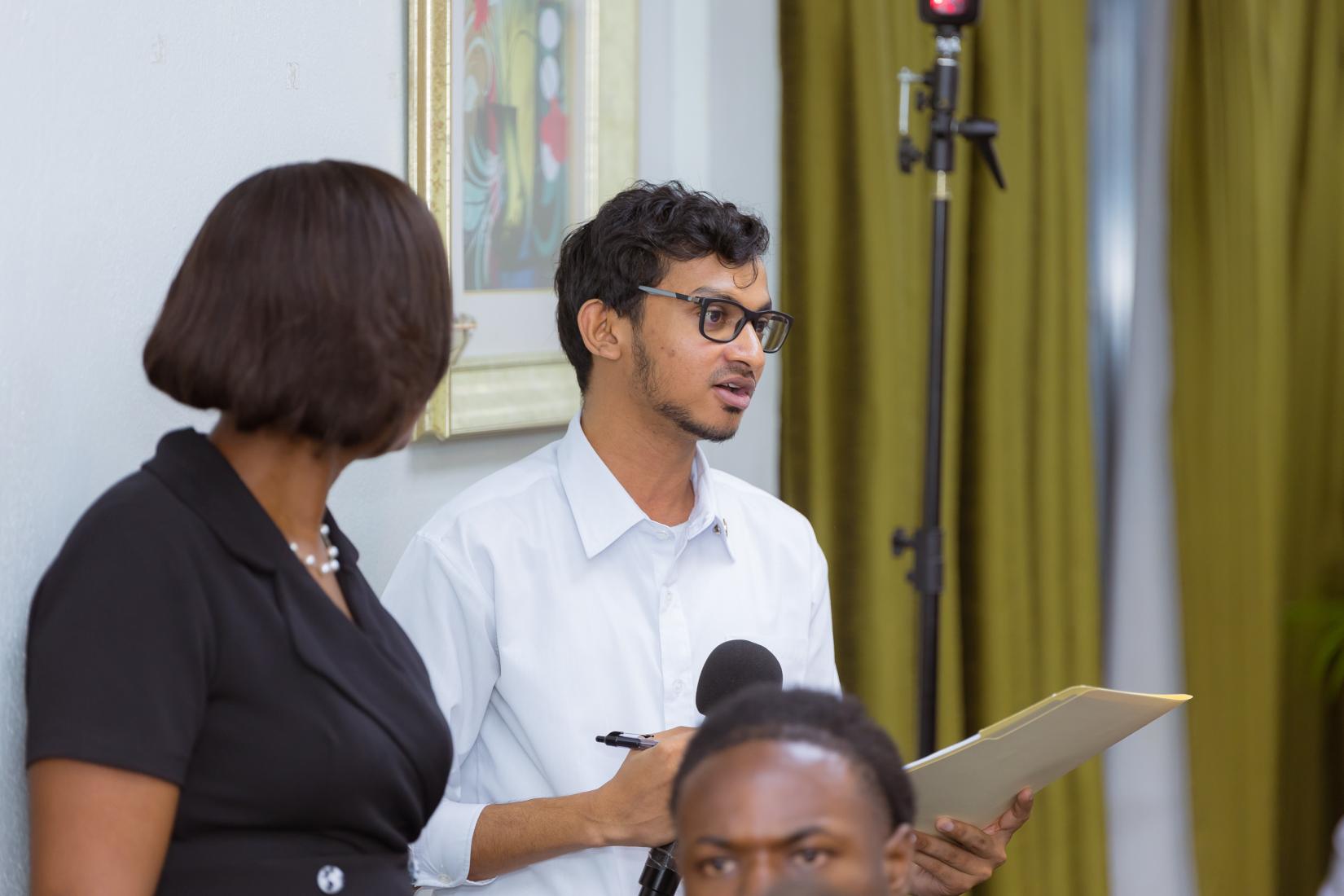 A young man standing holding a microphone.