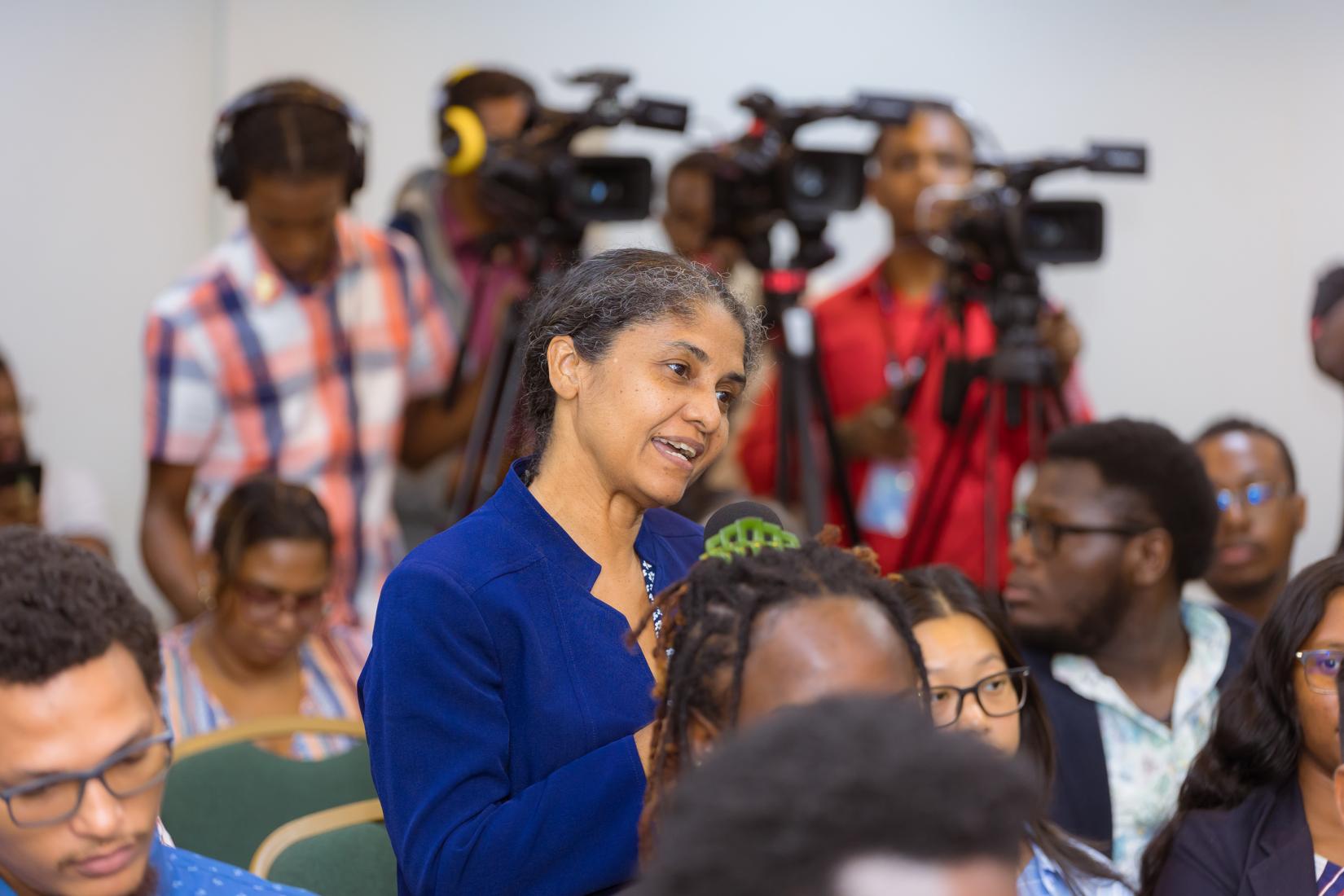 A lady standing asking a question.