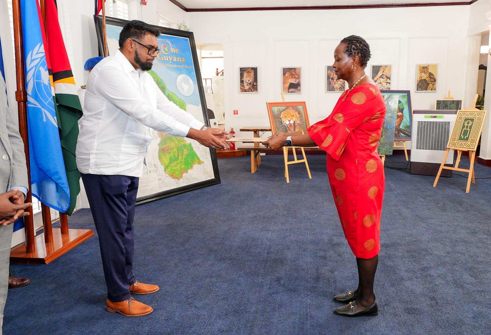 A woman giving a man a folder.