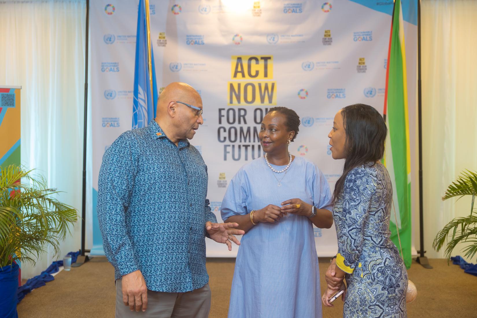 A man and two women standing talking.