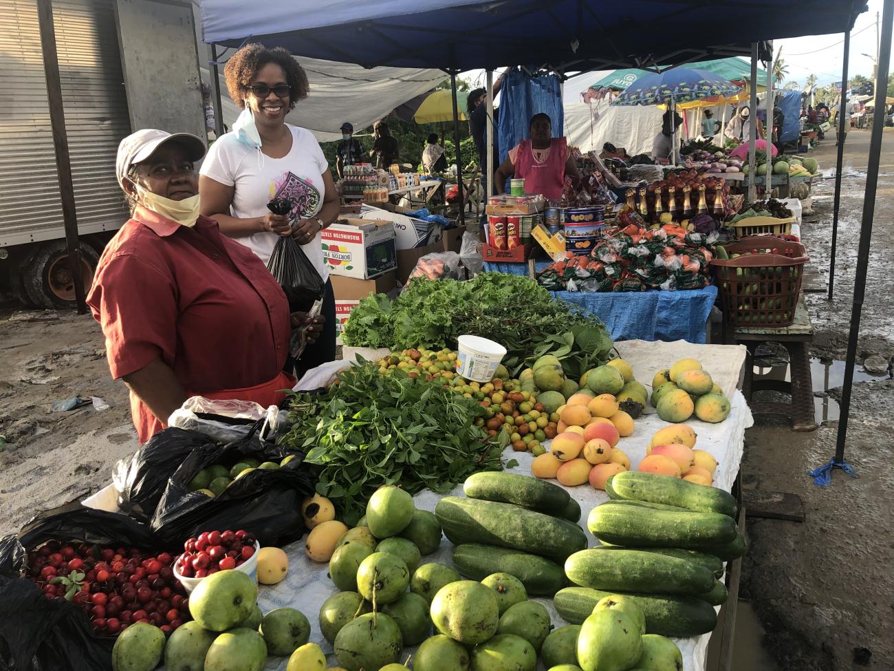 FAO Representative for Guyana Dr. Gillian Smith visits the stall of a local market vendor.