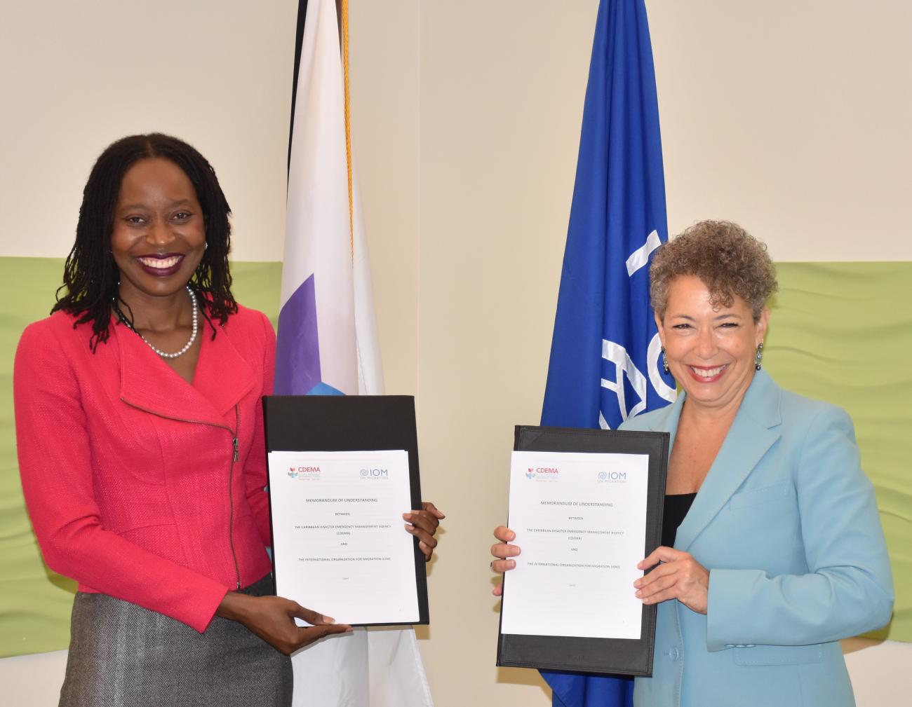 Two women standing holding up a signed document.