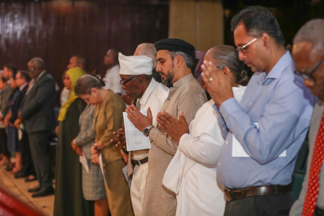 A group of people, some with prayer hands.