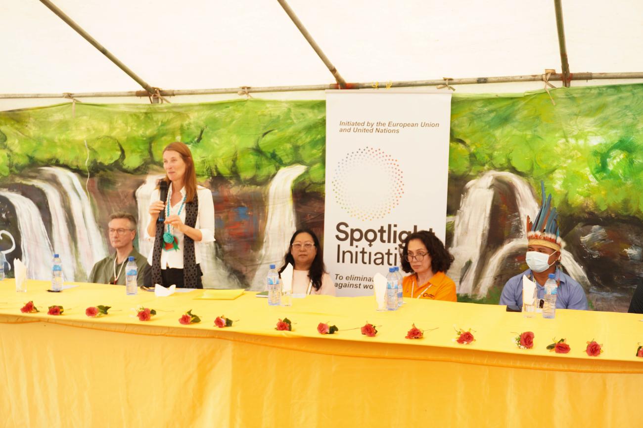 A woman (Helena KÖNIG) standing while addressing a group of people.