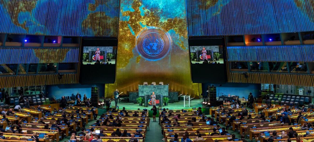 A woman singing in front of a seated audience at UN Headquarters.