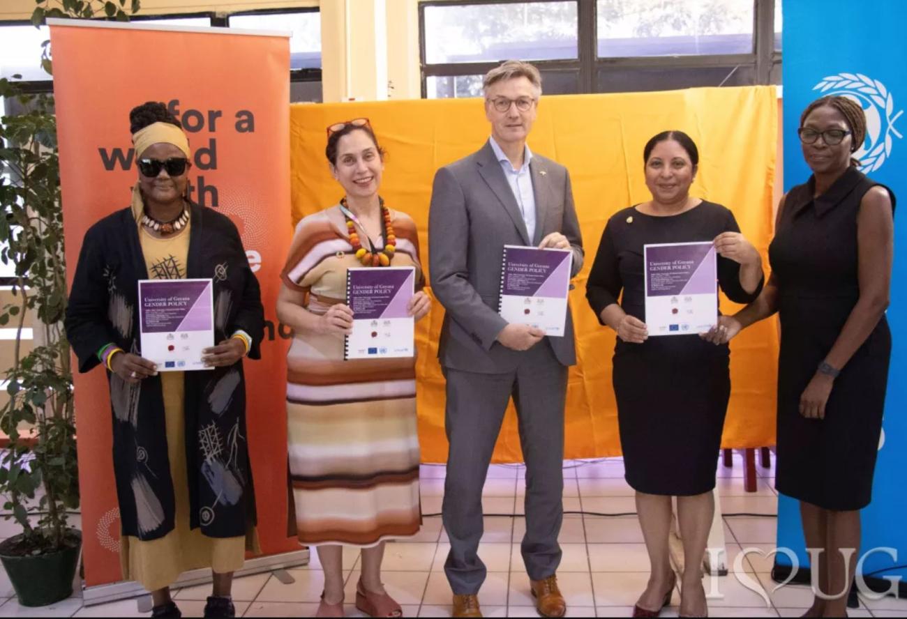 4 women and 1 man holding copies of the Gender Policy