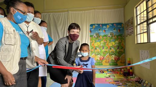 Executive Director of the Caribbean Regional Development Program, Global Affairs Canada, Sharon Peake assists a child to cut the ribbon to officially open the ECD space at the Annai Health Centre on Monday, 22 November 2021.