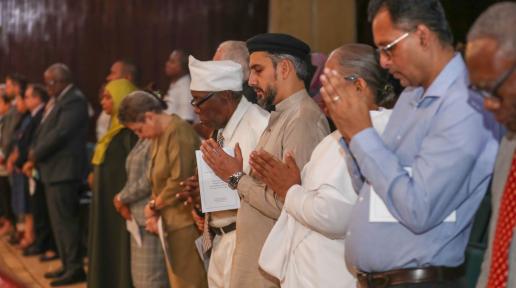 A group of people, some with prayer hands.