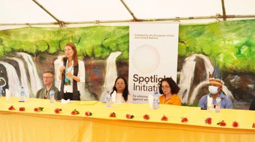 A woman (Helena KÖNIG) standing while addressing a group of people.