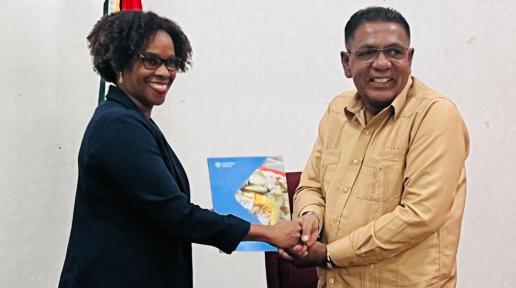 FAO Representative Dr. Gillian Smith hands over a manual to Guyana's Minister of Agriculture Zulfikar Mustapha