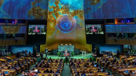A woman singing in front of a seated audience at UN Headquarters.